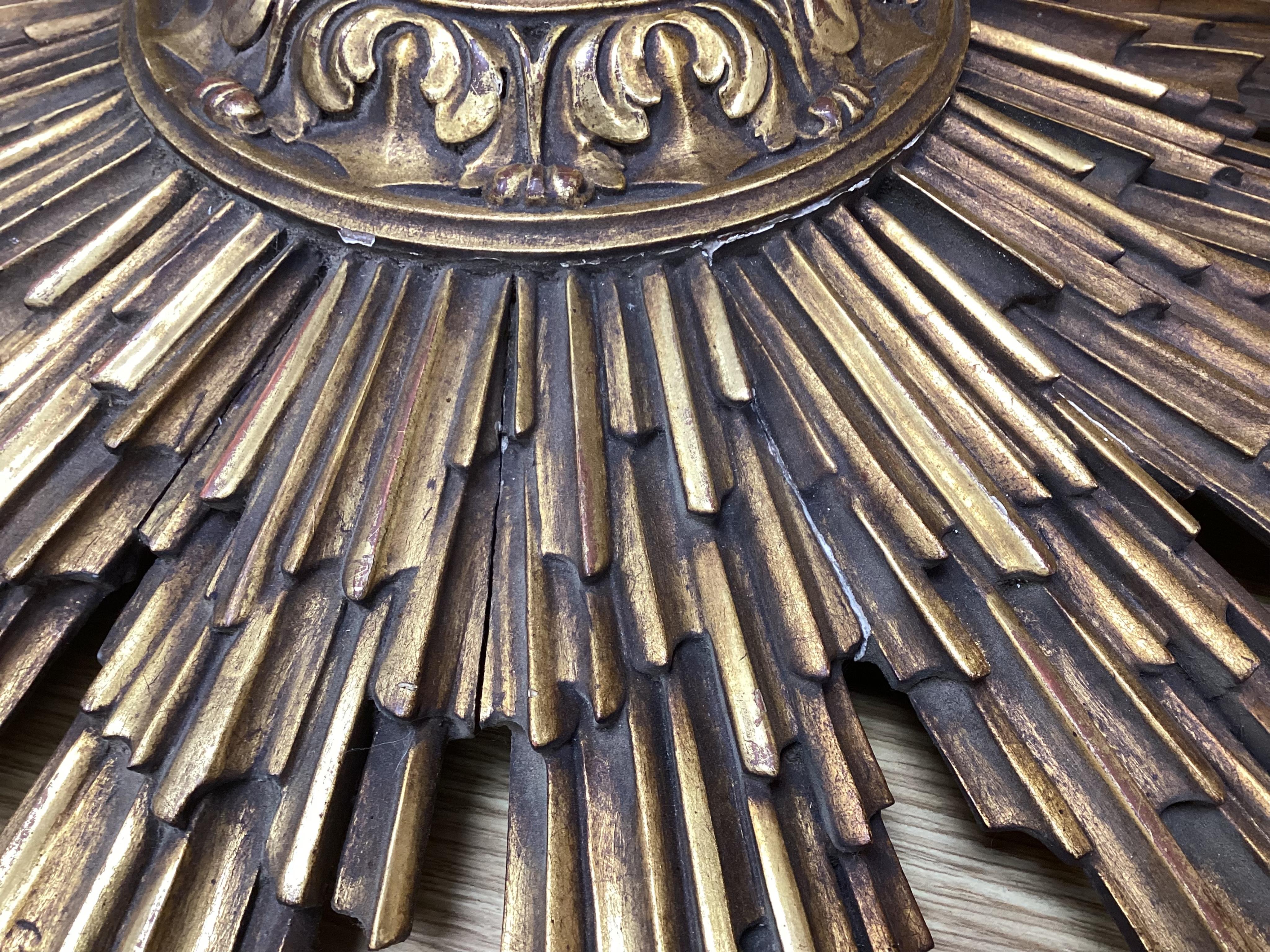 A gilt decorated sun burst clock frame, 63cm wide and a mid 19th century ornate gilt miniature frame